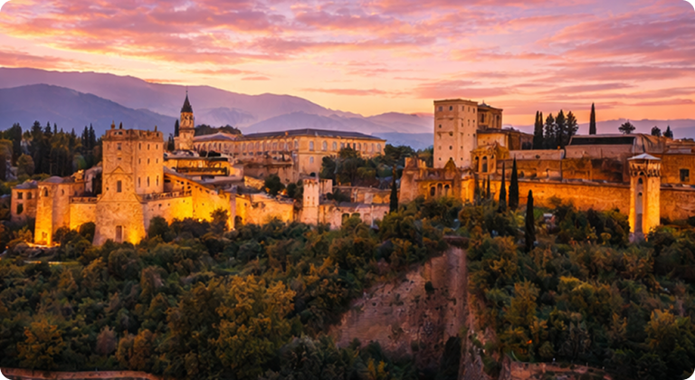 Alhambra palace and fortress illuminated at sunset with Sierra Nevada mountains