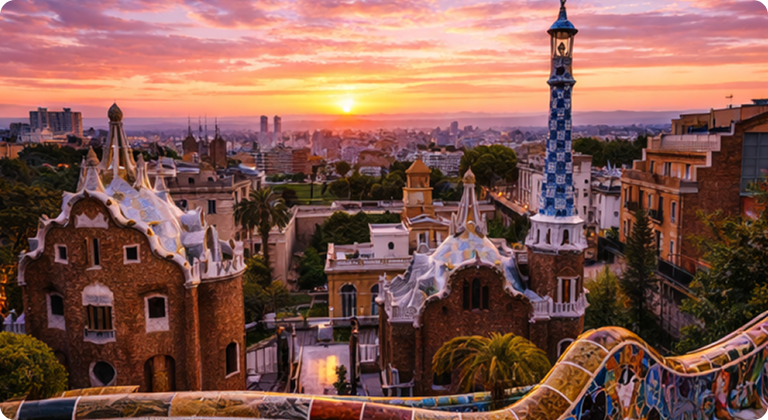 Park Güell colorful mosaic benches and whimsical architecture at sunset overlooking Barcelona